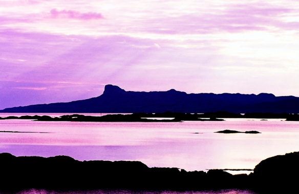 The beautiful island of Eigg, one of the Western isles of Scotland in silhouette. Photograph given watercolor treatment.